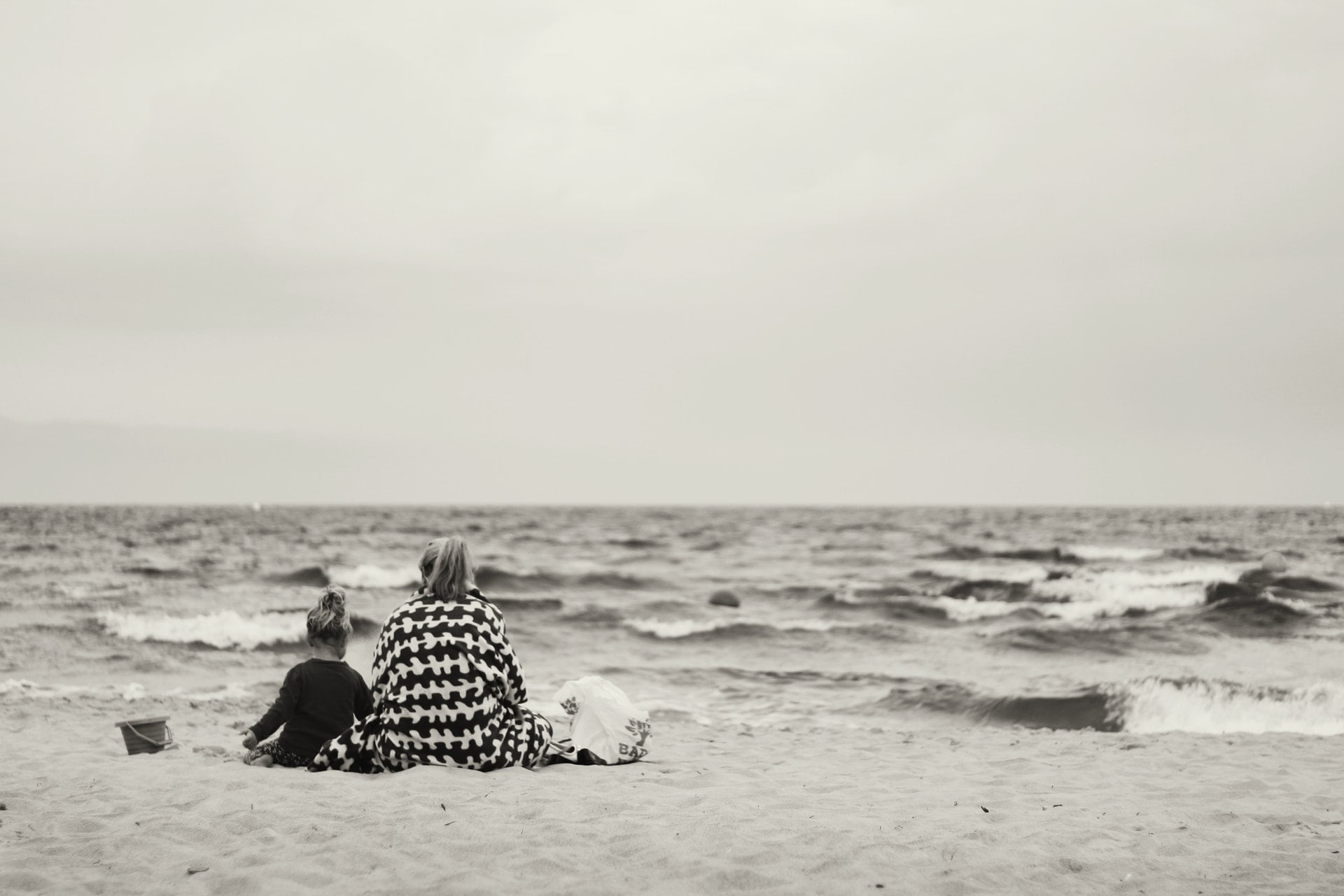 離｜藍雀一行詩 woman and child sitting on sand near body of water mother ocean 1